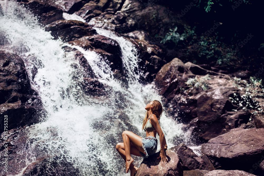  beautiful attractive girl under the sun on a waterfall
