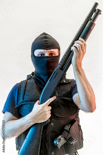 Murderer, man armed with balaclava and bulletproof vest, gun and shotgun, kalashnikov