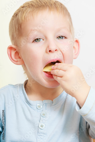 Little boy eating apple for snack