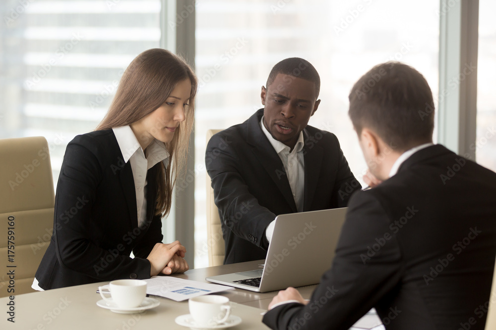 Group of multinational financiers working together on company strategy, planning financial results, examining marketing researches. Black businessman consulting with caucasian colleagues in office Group of multinational financiers working together on company strategy, planning financial results, examining marketing researches. Black businessman consulting with caucasian colleagues in office