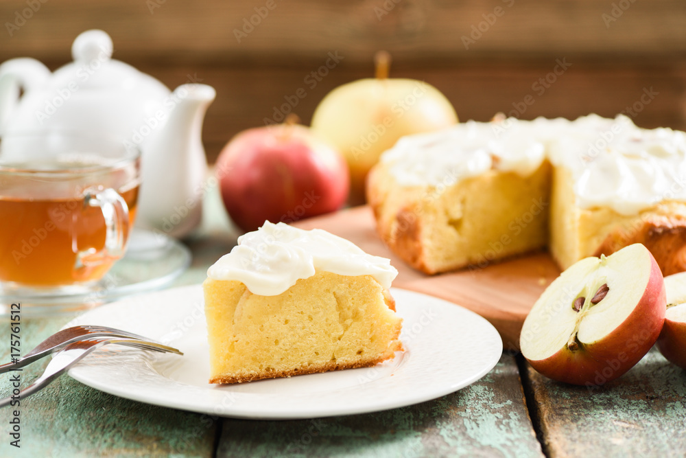 Autumn dessert. Homemade apple cake with whipped cream served with black tea and raw apples on robin egg blue table Autumn dessert. Homemade apple cake with whipped cream served with black tea and raw apples on robin egg blue table