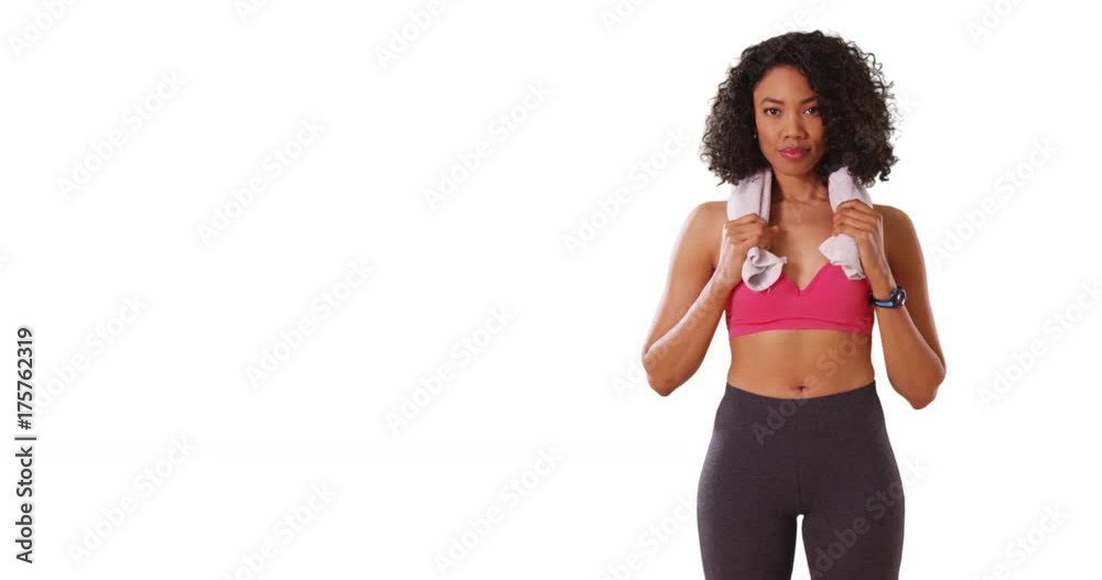Portrait of fit black female holding towel around neck after workout in studio Portrait of fit black female holding towel around neck after workout in studio