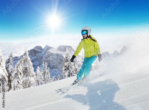 Young woman skier running down the slope in Alpine mountains