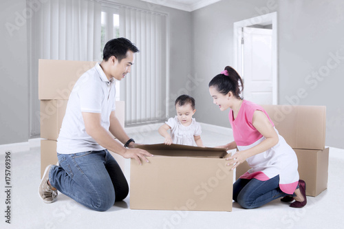 Family unpacking cardboard in the new home