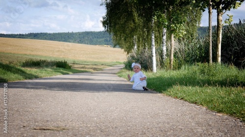 the child is sitting on the road