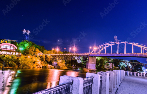 Beautiful Night view of an Artificial Waterfall and footbridge on Monastyrsky Island in the city of Dnepr on the river.. Dnepropetrovsk, Dnipropetrovsk, Dnipro city, Ukraine photo