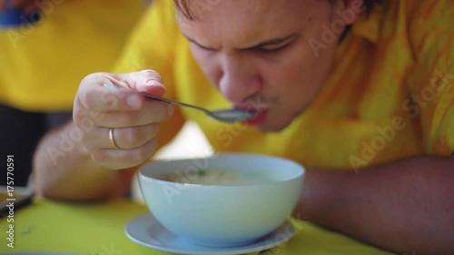Man eating chicken coconut soup in beach cafe. 1920x1080