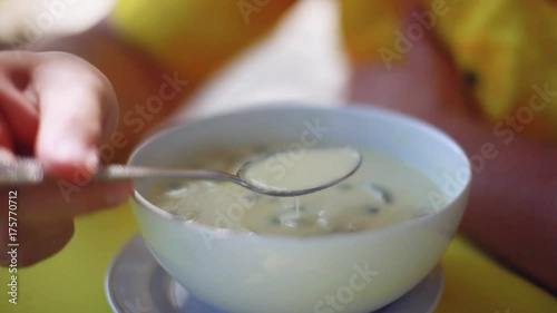 Man eating chicken coconut soup in dish. Closeup. 1920x1080