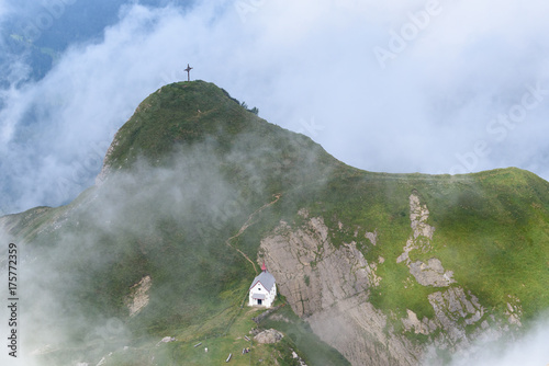 Cross and church on foggy hill top