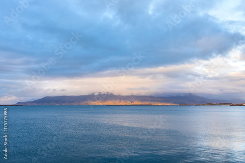 Embankment of Reykjavik with mountains and blue ocean.