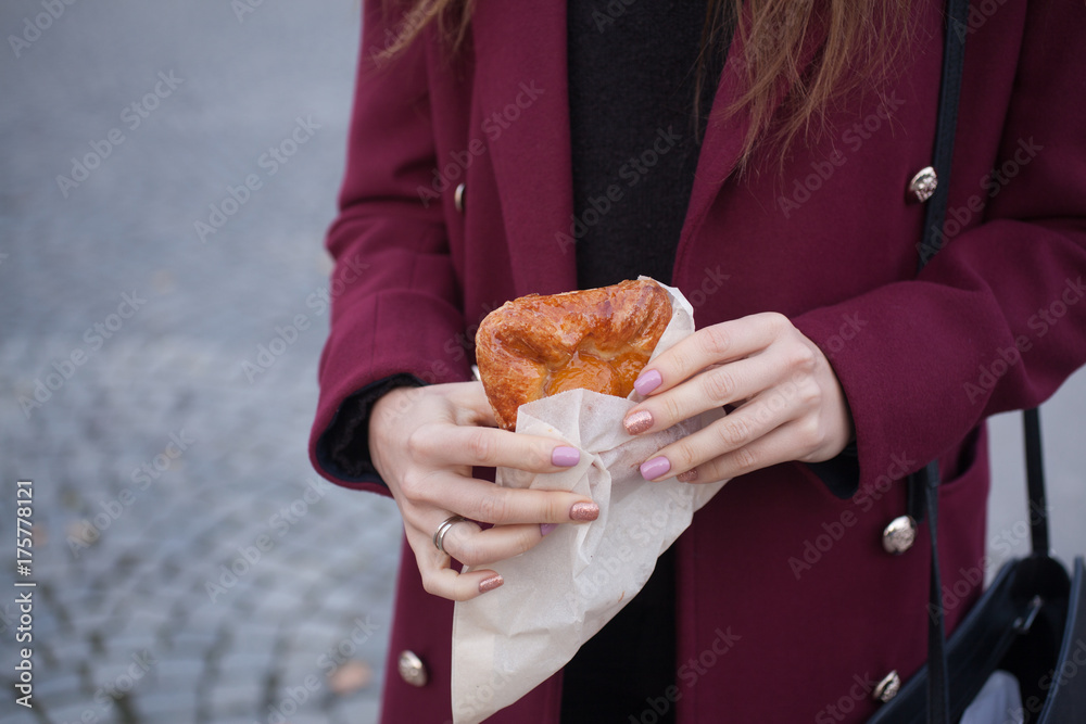 the woman on the street holds food cakes