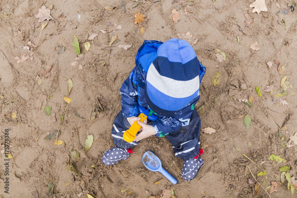 baby playing in the sand in autumn baby playing in the sand in autumn