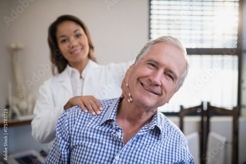 Portrait of smiling female therapist massaging neck