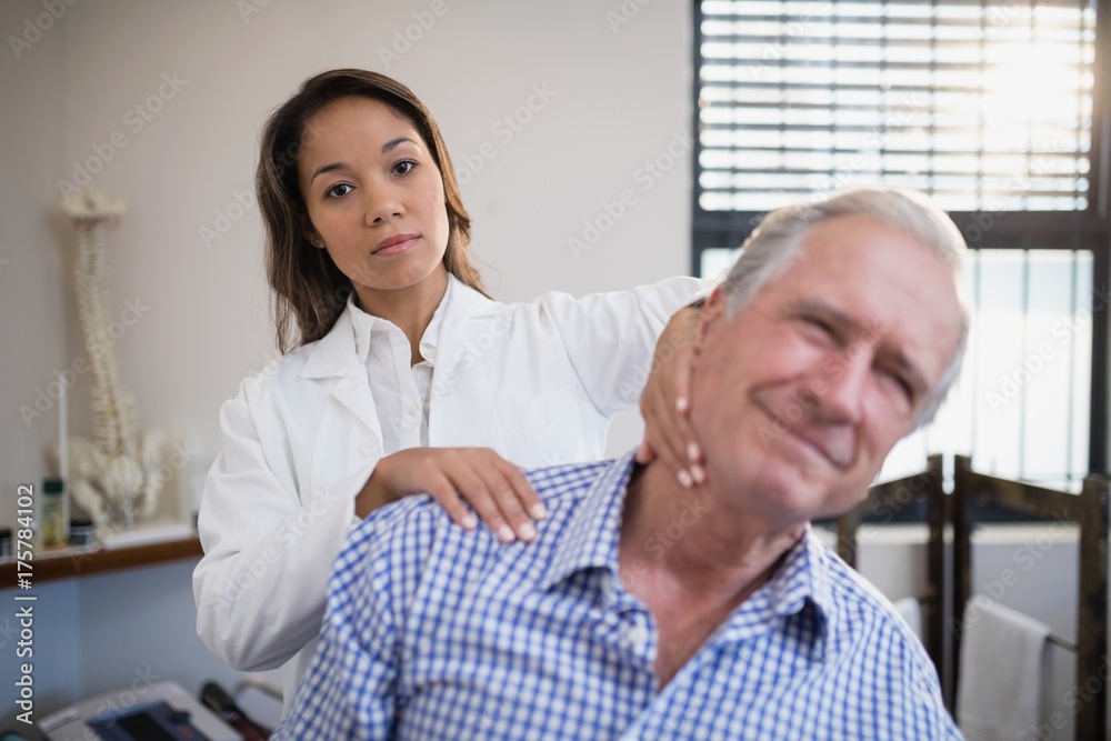 Obraz premium Portrait of female therapist giving neck massage to senior male