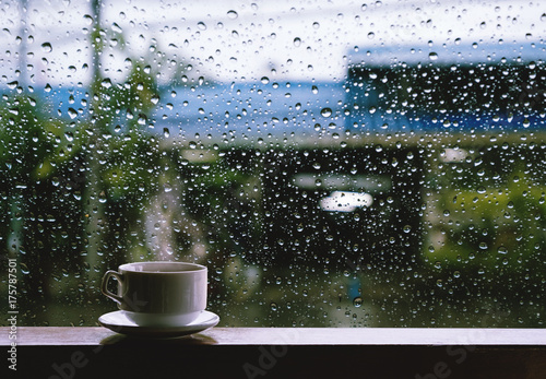 Cup of Hot Drinks on wooden table in rainy day photo