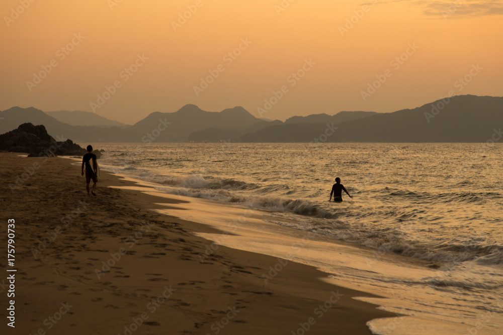 サーファーと海の夕焼け