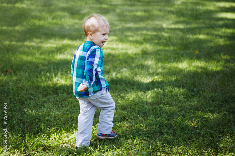 Little boy having fun playing in the Park on the grass Little boy having fun playing in the Park on the grass
