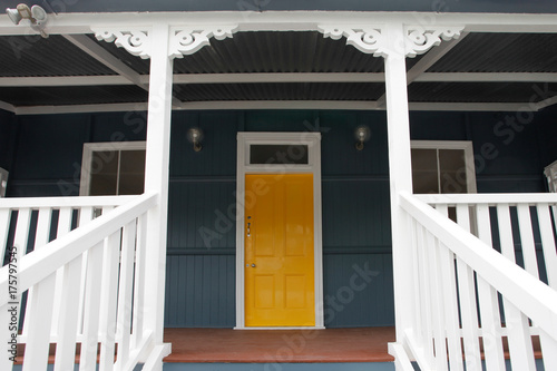 Details of a freshly painted Queensland colonial home with a welcoming sunshine yellow front door.