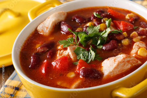 Traditional chicken chili stew with beans, corn and tomatoes close up. horizontal