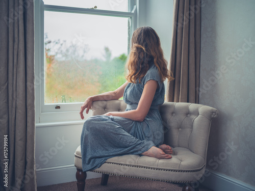 Young woman daydreaming by window