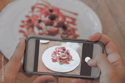 Using a mobile phone, take a photo of the dessert. photo