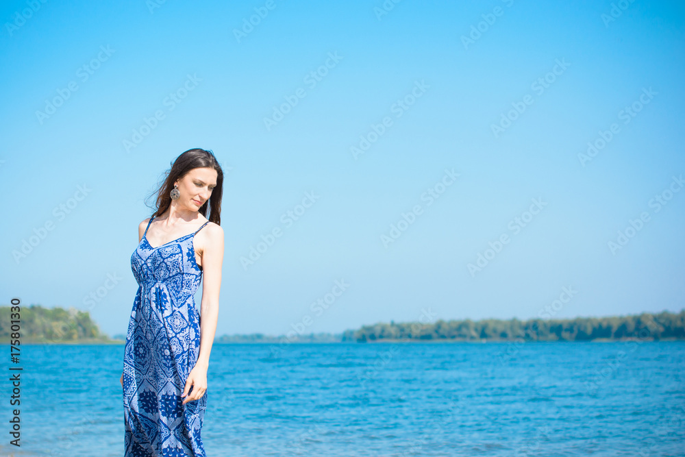 A middle-aged woman with a lean figure on vacation enjoys life and a good day in the beams of the sun A middle-aged woman with a lean figure on vacation enjoys life and a good day in the beams of the sun