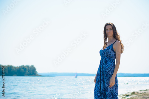 A middle-aged woman with a lean figure on vacation enjoys life and a good day in the beams of the sun