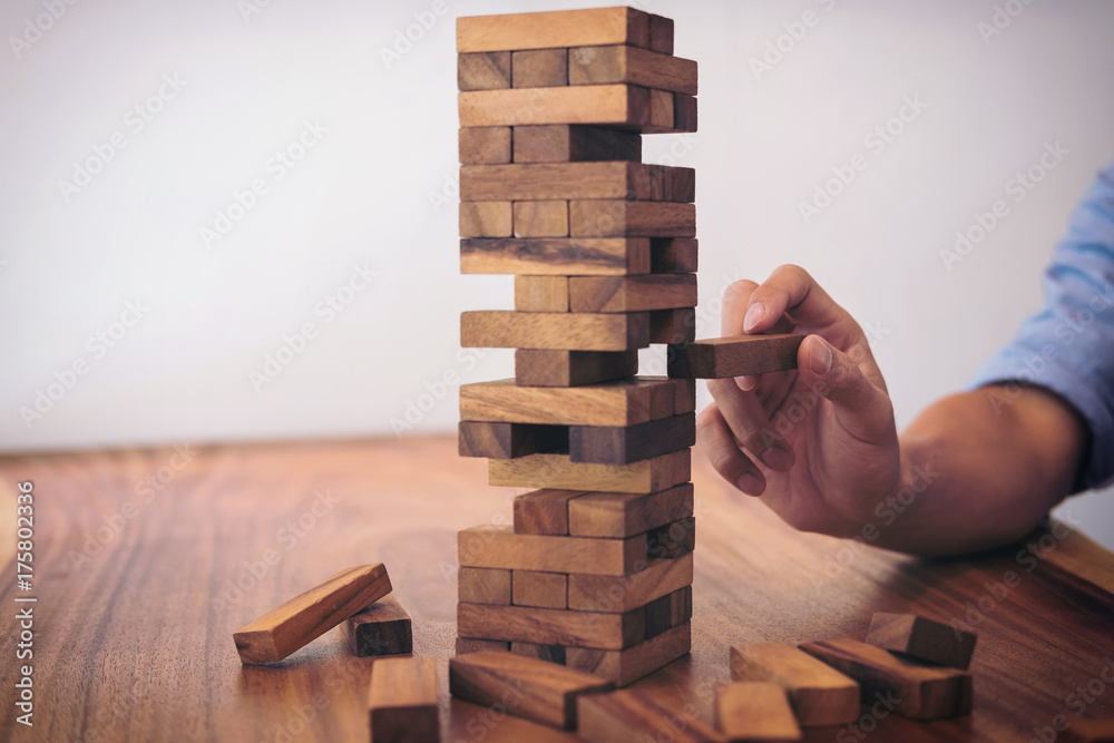 Images of hand of businesspeople placing and pulling wood block on the tower, Alternative risk concept, plan and strategy in business, Risk To Make Business Growth Concept With Wooden Blocks Images of hand of businesspeople placing and pulling wood block on the tower, Alternative risk concept, plan and strategy in business, Risk To Make Business Growth Concept With Wooden Blocks