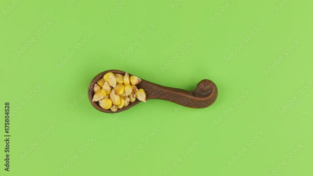 Zoom of a clay spoon with corn grain. Chroma key, green screen. Zoom of a clay spoon with corn grain. Chroma key, green screen.