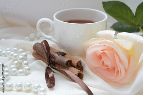 romantic Breakfast, a Cup of aromatic morning tea , shining pearls and cinnamon sticks to create a wonderful mood for the whole day photo