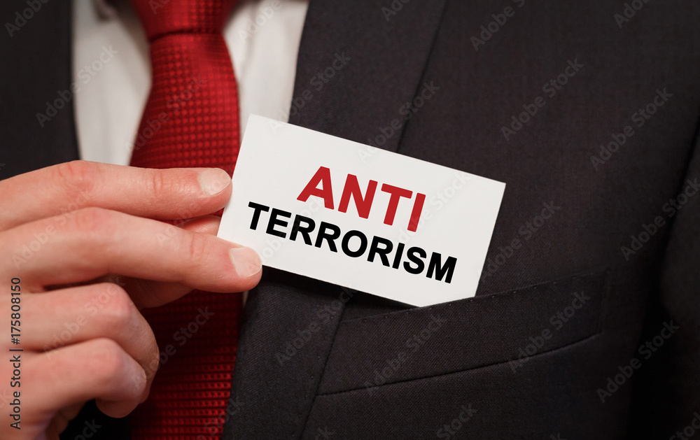 Businessman putting a card with text Anti Terrorism in the pocket Businessman putting a card with text Anti Terrorism in the pocket
