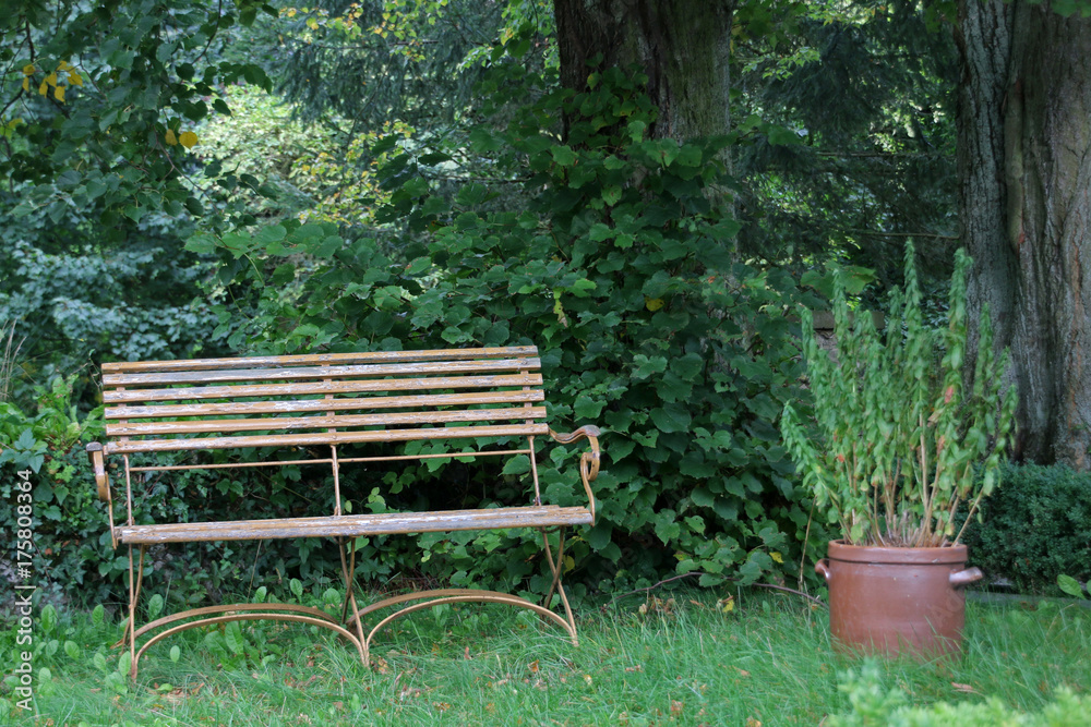 Rote Gartenbank mit Blumenkübel