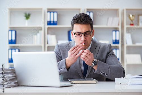 Businessman smoking in office at work