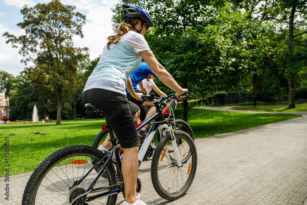 Healthy lifestyle - people riding bicycles in city park Healthy lifestyle - people riding bicycles in city park