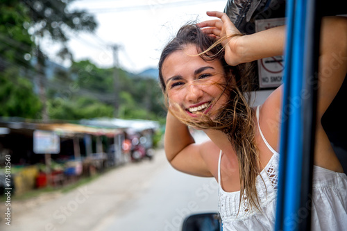 Photography smiling girl looks out of the window of a taxi, tuk-Tuk