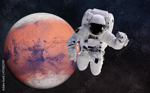 Fototapeta Naklejka Na Ścianę i Meble -  astronaut performing a space walk around the red planet Mars 