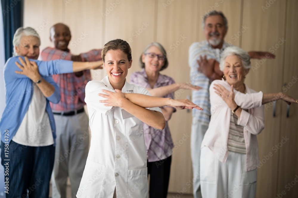 Portrait of smiling female doctor and seniors stretching arm