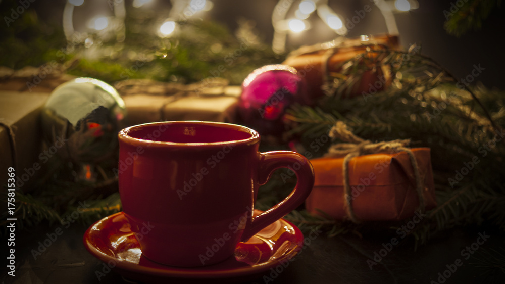New Year's toys and gifts and cup on the background of the Christmas tree concept of the holiday new year New Year's toys and gifts and cup on the background of the Christmas tree concept of the holiday new year