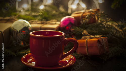 New Year's toys and gifts and cup on the background of the Christmas tree concept of the holiday new year