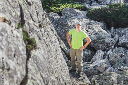 young man hiker looking at the rocky cliff