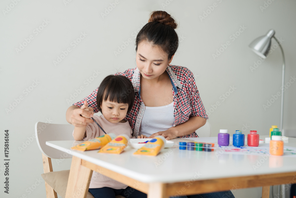 Little girl painting with her mother at home Little girl painting with her mother at home