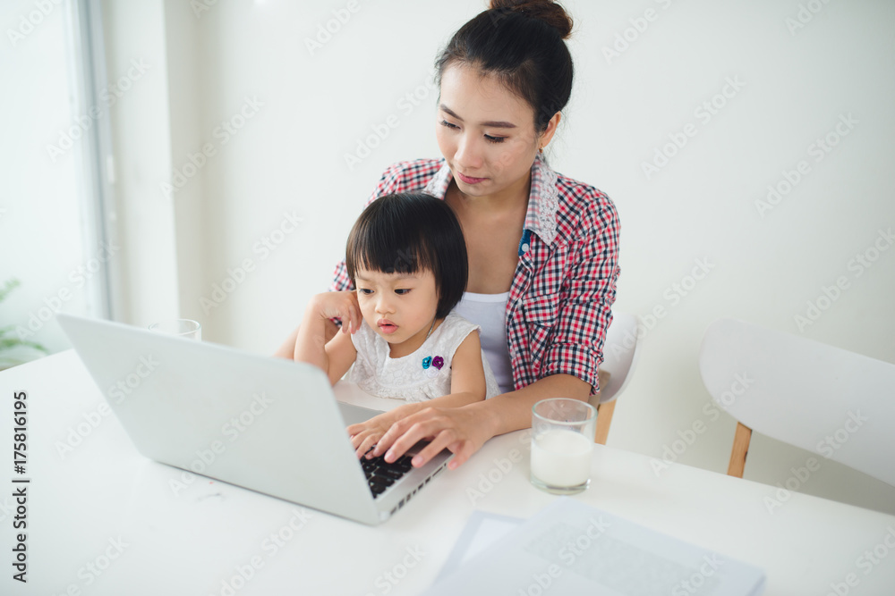 Asian mother woman with a her daughter working at the computer Asian mother woman with a her daughter working at the computer