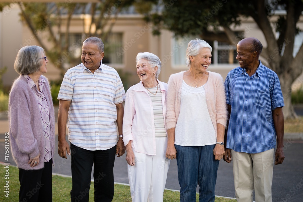 Cheerful seniors standing while looking at each other Cheerful seniors standing while looking at each other