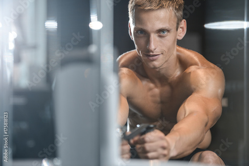 Handsome model young man training back in gym