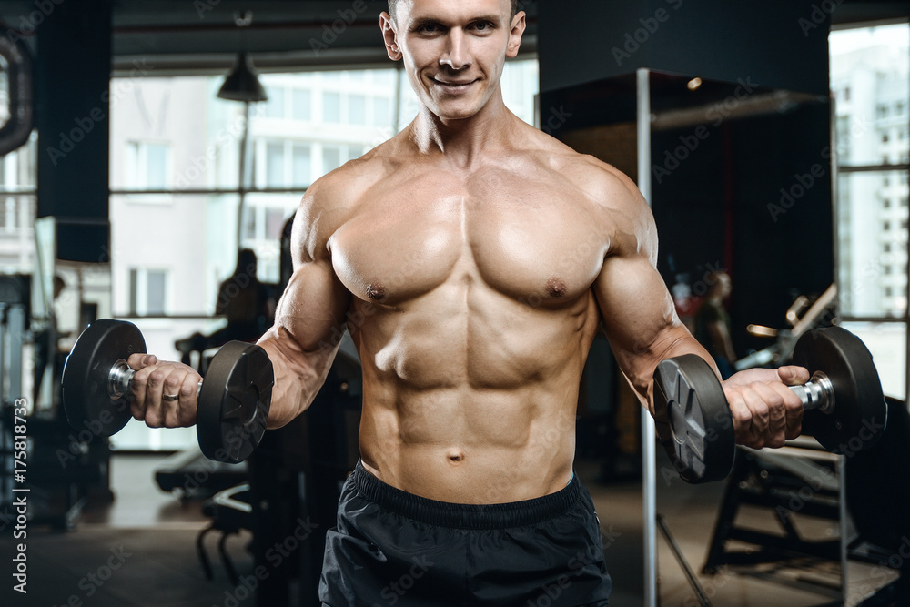 Handsome model young man training arms in gym