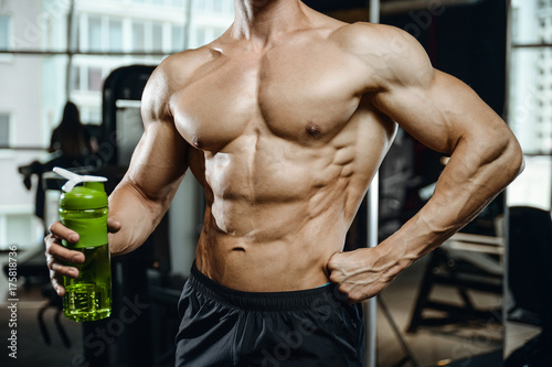 Handsome model young man takes sports nutrition