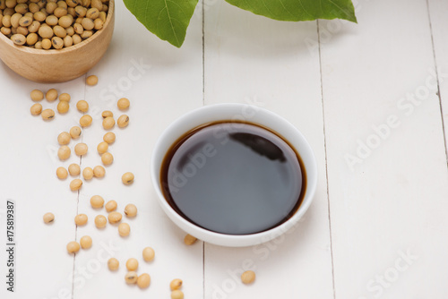 Soy sauce and soy bean on wooden table