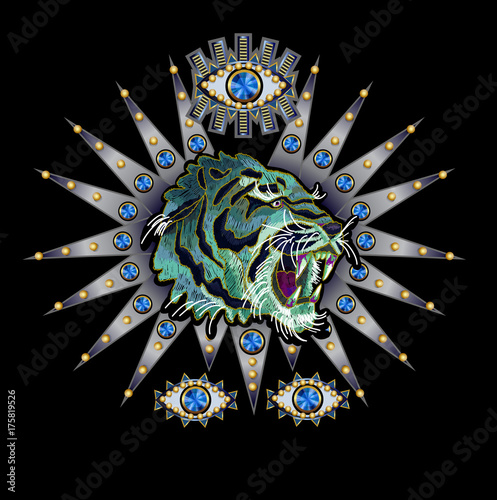 Tiger, eye on a silver background embroidery patch with sequins and beads for textile design.