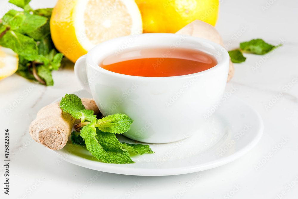Cup of ginger tea with lemon,fresh mint and honey, on white marble table, copy space Cup of ginger tea with lemon,fresh mint and honey, on white marble table, copy space