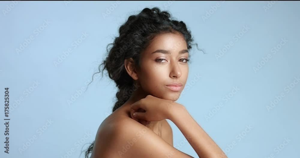 Cute young Middle Eastern model with nude shoulders and lightly braided wavy black hair and beautiful smooth skin vídeo de Stock | Adobe Stock